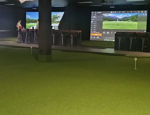 Sim bay with lounge chairs at 3 Putt Golf Club in Goldsboro, NC