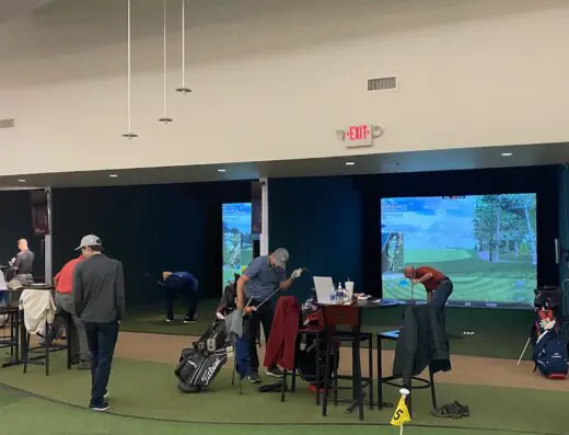 Practice bays with players at a distance at Elevation Golf Academy Indianapolis in Carmel, IN