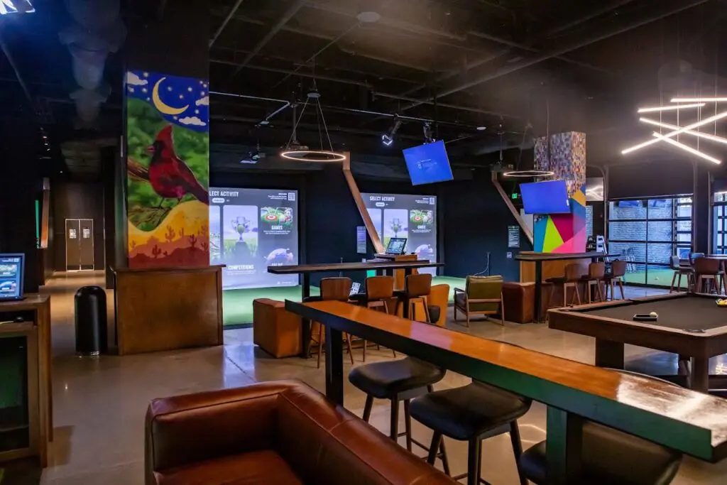 Simulator bays, pool table and mural inside Five Iron Golf in downtown Nashville