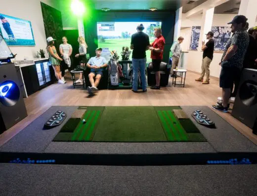 Row of bays with players at a distance at Golf Envy Eagle in Eagle, ID