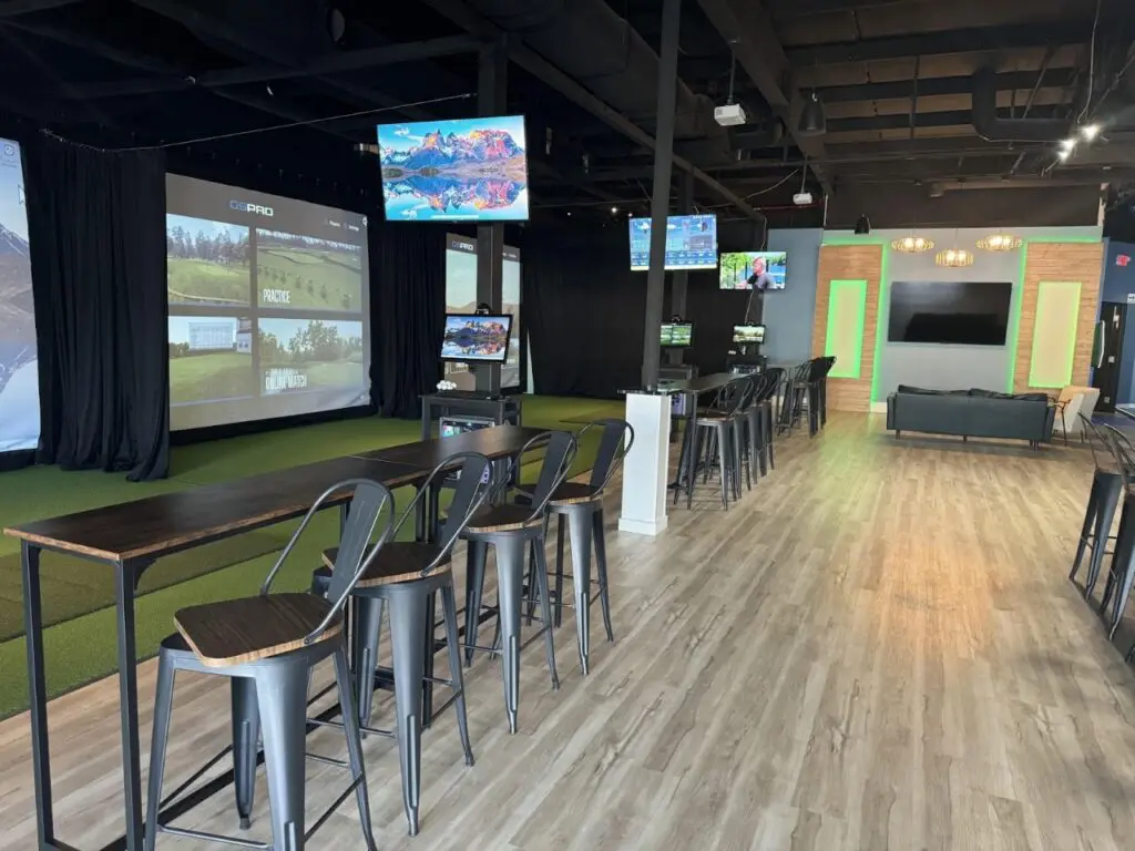 Simulator bays and bar seating inside Impact Golf Lounge in Charlotte, North Carolina