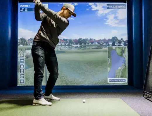 Golfer in a sim bay at One Under Golf Club in Orange City, IA