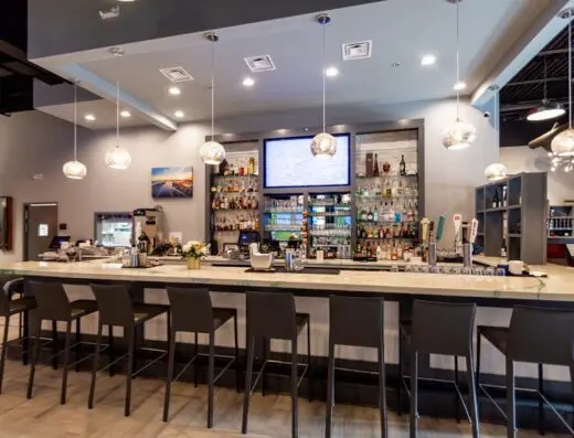 Bar with sim screens and TVs behind at Rounds Golf & Lounge in Wilmington, NC