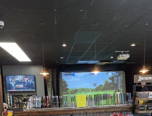 Sim bay with a screen and clubs on the shop wall at The Turn in White Hall, WV