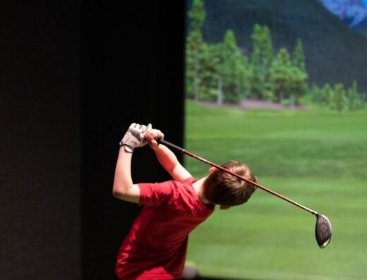 Golfer swinging in a bay at Back9 Parlor in Lynnwood, WA