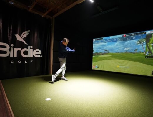 Golfer hitting in a simulator bay at Birdie Golf in Ogden, UT