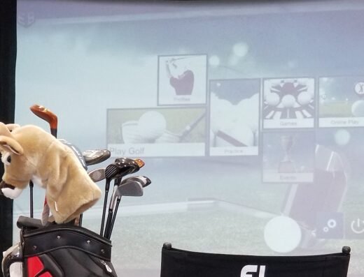 Golfer swinging in a sim bay at Rocky Mountain Golf Company in Bozeman, MT