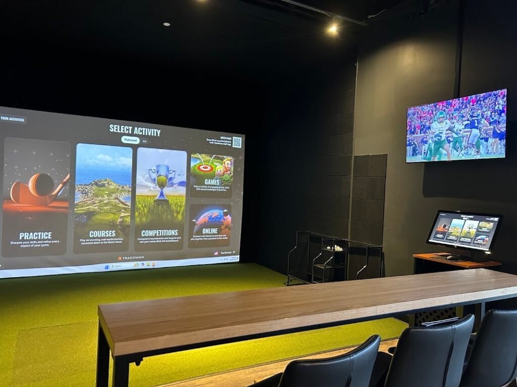TrackMan simulator bay with a lounge table inside The Fairway Columbus in Upper Arlington, Ohio