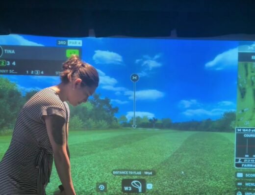 Golfer in a simulator bay at X-Golf Rochester in Rochester, MN
